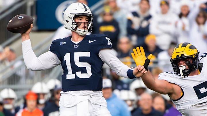 Penn State quarterback Drew Allar (15) throws under pressure from Michigan's Mason Graham in the