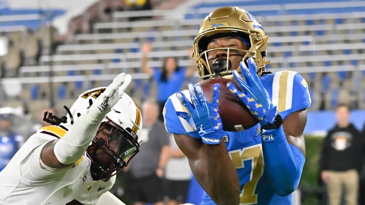 Oct 12, 2024; Pasadena, California, USA; UCLA Bruins wide receiver J.Michael Sturdivant (7) hauls in a 42-yard touchdown pass past Minnesota Golden Gophers defensive back Ethan Robinson (2) for a fourth quarter touchdown at Rose Bowl. Mandatory Credit: Robert Hanashiro-Imagn Images