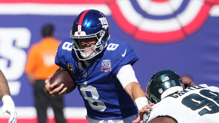 Oct 20, 2024; East Rutherford, New Jersey, USA;  New York Giants quarterback Daniel Jones (8) runs past Philadelphia Eagles defensive tackle Jalen Carter (98) during the first half at MetLife Stadium.  