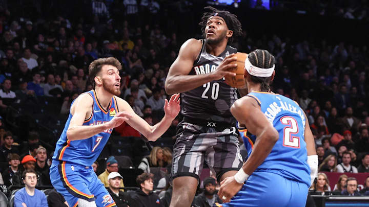 Feb 26, 2025; Brooklyn, New York, USA;  Brooklyn Nets center Day'Ron Sharpe (20) looks to drive past Oklahoma City Thunder forward Chet Holmgren (7) and guard Shai Gilgeous-Alexander (2) in the third quarter at Barclays Center. Mandatory Credit: Wendell Cruz-Imagn Images