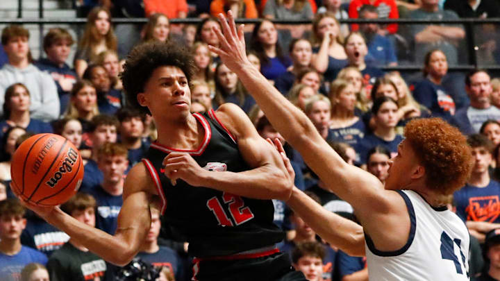 Fishers Tigers Justin Kirby (12) passes the ball past Harrison Raiders forward Malachi King (41) Saturday, March 15, 2025, during the IHSAA boys basketball 4A regional championship game at Frankfort High School in Frankfort, Ind. Fishers won 89-39. Fishers Tigers Justin Kirby (12) passes the ball past Harrison Raiders forward Malachi King (41) Saturday, March 15, 2025, during the IHSAA boys basketball 4A regional championship game at Frankfort High School in Frankfort, Ind. Fishers won 89-39.