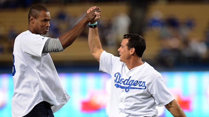 NBA player Jason Collins (left) and former Los Angeles Dodgers outfielder Billy Bean (right) celebrate after throwing out the first pitch at the first annual LGBT Night Out at Dodger Stadium prior to the game against the Los Angeles Dodgers and the Colorado Rockies on Sept. 27, 2013.
