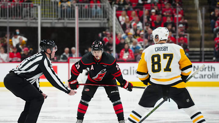 Jan 5, 2025; Raleigh, North Carolina, USA;  Carolina Hurricanes center Sebastian Aho (20) gets ready to take a face off against Pittsburgh Penguins center Sidney Crosby (87) during the third period at Lenovo Center. Mandatory Credit: James Guillory-Imagn Images