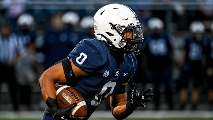 East Lansing's Jace Clarizio runs for a gain against DeWitt during the first quarter on Friday, Sept. 27, 2024, at East Lansing High School.