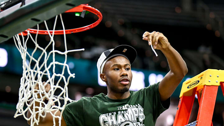 Michigan State's Tre Holloman shows off a piece of the net he helped cut down while the Spartans celebrate the Big Ten title after the game against Michigan on Sunday, March 9, 2025, at the Breslin Center in East Lansing.