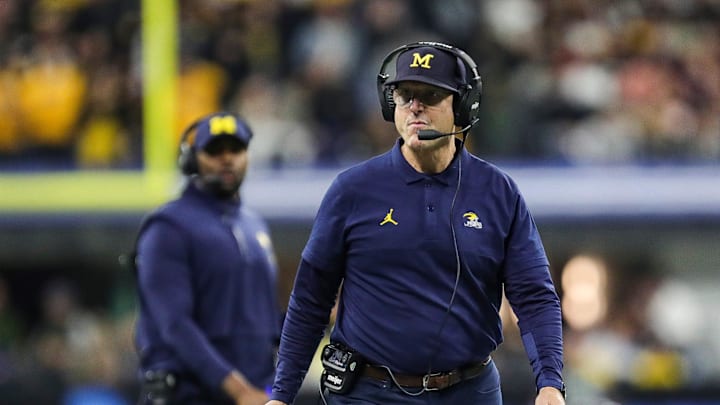 Michigan head coach Jim Harbaugh walks on the field for a timeout against Iowa during the first half