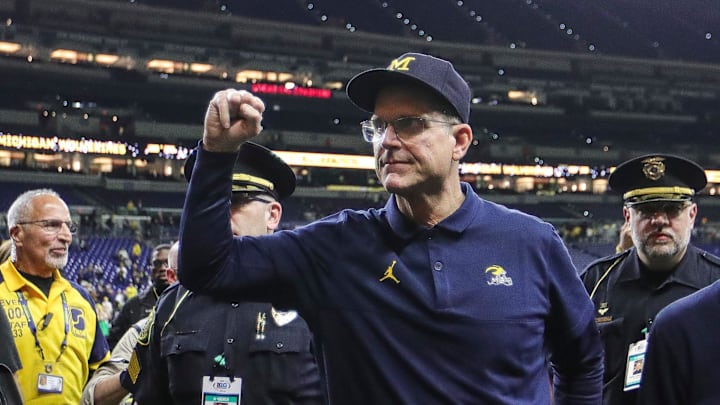 Michigan football coach Jim Harbaugh waves at fans after the Wolverines' 26-0 win over Iowa in the