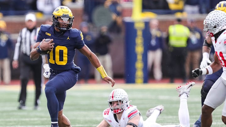 Michigan quarterback Alex Orji runs past Ohio State linebacker Tommy Eichenberg (35) during the second half at Michigan Stadium in Ann Arbor on Saturday, Nov. 25, 2023.