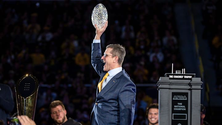 Michigan head coach Jim Harbaugh lifts the AFCA Coaches' Trophy during the national championship celebration at Crisler Center in Ann Arbor on Saturday, Jan. 13, 2024.