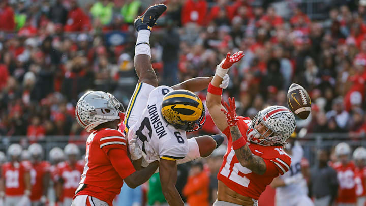 Michigan wide receiver Cornelius Johnson (6) tries to make a catch against Ohio State cornerback JK Johnson and safety Lathan Ransom (12) during the second half Nov. 26, 2022 at Ohio Stadium in Columbus.