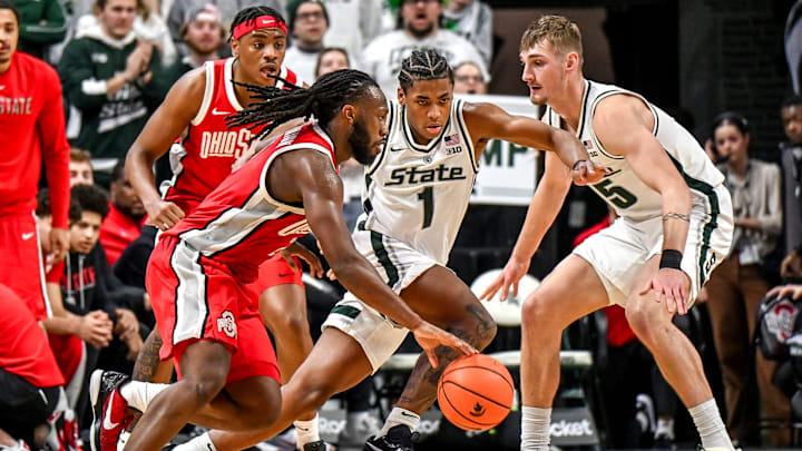 Michigan State's Jeremy Fears Jr., center, defends against Ohio State's Bruce Thornton, left, during the second half on Sunday, Feb. 22, 2026, at the Breslin Center in East Lansing.