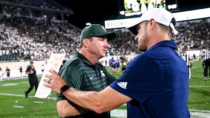 Michigan State's head coach Jonathan Smith, left shakes hands with Florida Atlantic's head coach Tom Herman after the game on Friday, Aug. 30, 2024, at Spartan Stadium in East Lansing.