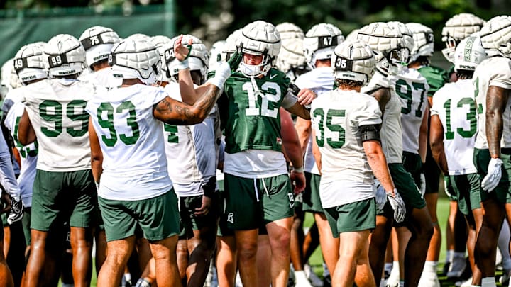 Michigan State's Jack Velling, right, high fives Jalen Satchell during the first day of football camp on Tuesday, July 30, 2024, in East Lansing.