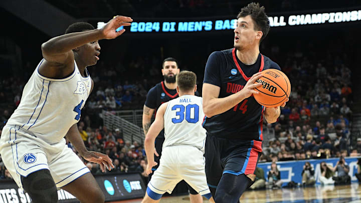 Mar 21, 2024; Omaha, NE, USA; Duquesne Dukes forward Matus Hronsky (14) drives against Brigham Young Cougars forward Fousseyni Traore (45) in the first half during the first round of the NCAA Tournament at CHI Health Center Omaha. Mandatory Credit: Steven Branscombe-Imagn Images