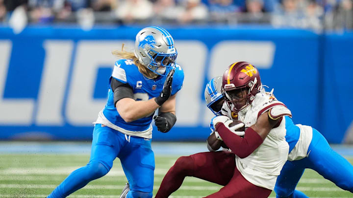 Detroit Lions linebacker Alex Anzalone (34) and Detroit Lions cornerback Terrion Arnold (0) take down Washington Commanders wide receiver Terry McLaurin (17) in the NFC divisional round at Ford Field in Detroit on Saturday, Jan. 18, 2025.