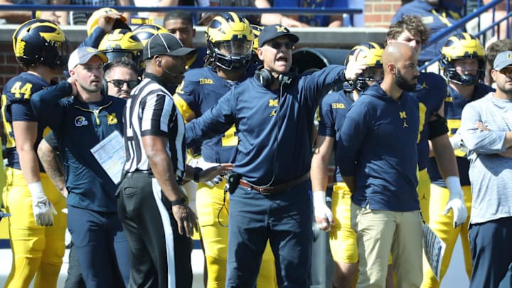 Michigan analyst Connor Stalions, left, next to coach Jim Harbaugh during Michigan's 31-7 win over
