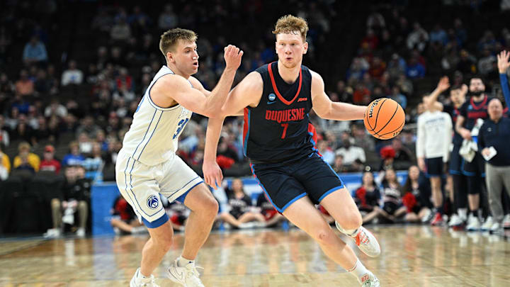 Mar 21, 2024; Omaha, NE, USA; Duquesne Dukes forward Jakub Necas (7) drives against Brigham Young Cougars guard Dallin Hall (30) in the first half during the first round of the NCAA Tournament at CHI Health Center Omaha. Mandatory Credit: Steven Branscombe-Imagn Images