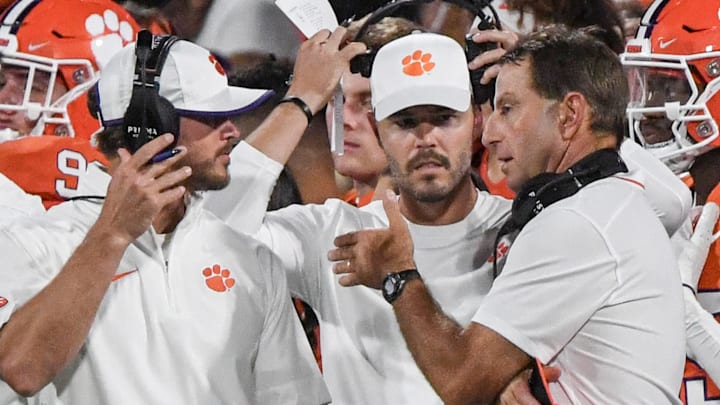Sep 16, 2023; Clemson, South Carolina; Clemson head coach Dabo Swinney talks with Clemson wide receiver coach Tyler Grisham, left, and offensive coordinator Garrett Riley, middle, during the fourth quarter with Florida Atlantic at Memorial Stadium.  Mandatory Credit: Ken Ruinard-USA TODAY NETWORK