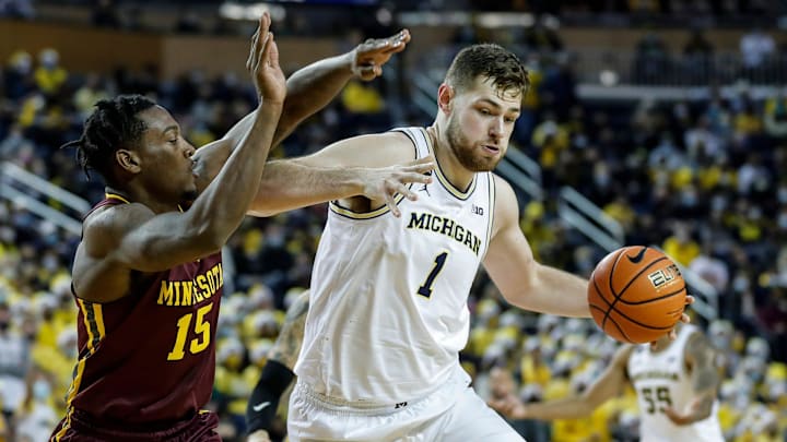 Michigan center Hunter Dickinson (1) dribbles against  Minnesota forward Charlie Daniels (15) during game vs. Minnesota
