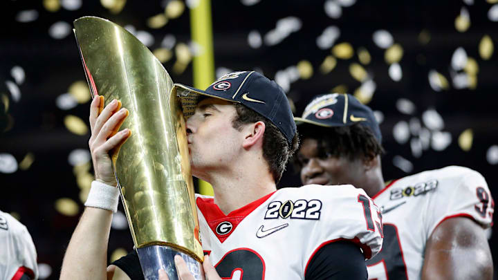 Georgia quarterback Stetson Bennett (13) kisses the trophy after winning the College Football