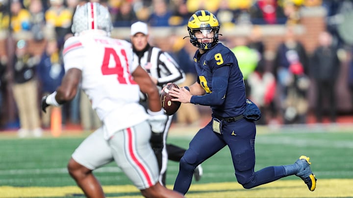 Michigan quarterback J.J. McCarthy runs against Ohio State safety Josh Proctor during the first half