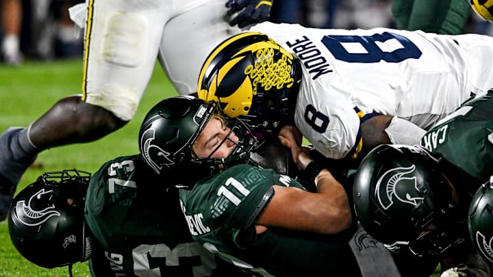 Michigan State's Alessio Milivojevic, bottom, is sacked by Michigan's Derrick Moore during the fourth quarter on Saturday, Oct. 25, 2025, at Spartan Stadium in East Lansing.