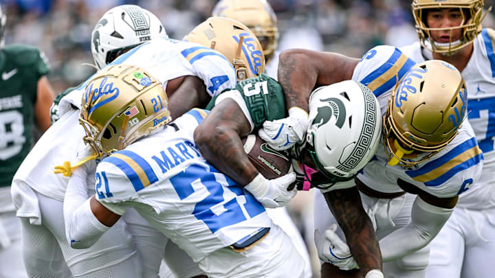 Michigan State's Makhi Frazier, center, is tackled by UCLA after a gain during the first quarter on Saturday, Oct. 11, 2025, at Spartan Stadium in East Lansing. Michigan State's Makhi Frazier, center, is tackled by UCLA after a gain during the first quarter on Saturday, Oct. 11, 2025, at Spartan Stadium in East Lansing.