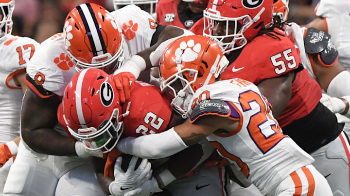 Aug 31, 2024; Atlanta, Georgia, USA; Clemson Tigers corner back Avieon Terrell (20) and defensive tackle Tre Williams (8) tackle Georgia Bulldogs running back Branson Robinson (22) during the first quarter of the 2024 Aflac Kickoff Game at Mercedes-Benz Stadium. 