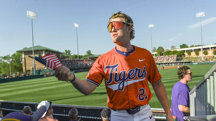Clemson infielder Jay Dillard (21), former T.L. Hanna High (Anderson, S.C.) standout, hands a veteran in right center field bleachers a U.S. flag during the middle of the fourth inning at Doug Kingsmore Stadum in Clemson, S.C. Friday, April 18, 2025.