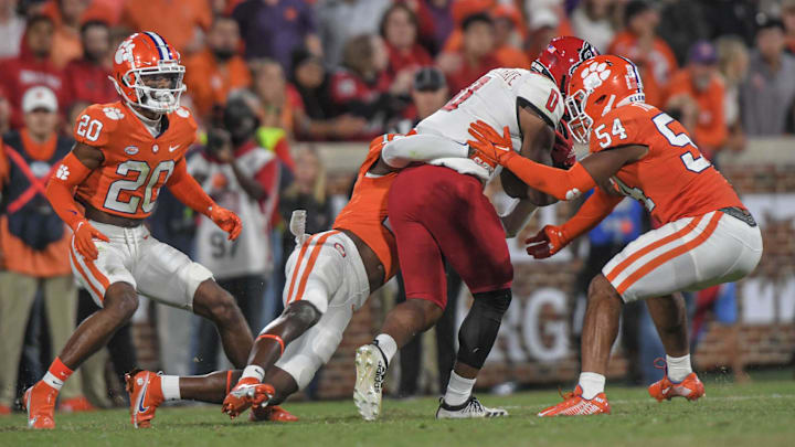 Clemson cornerback Nate Wiggins (20), left, watches as safety Sherrod Covil Jr (12) tackles North Carolina State Wolfpack running back Demie Sumo-Karngbaye (0) with linebacker Jeremiah Trotter Jr. (54) during the fourth quarter at Memorial Stadium in Clemson, South Carolina Saturday, October 1, 2022.

Ncaa Football Clemson Football Vs Nc State Wolfpack