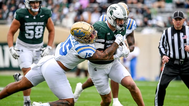 Michigan State's Jack Velling, right, runs after a catch as UCLA's Anthony Jones attempts the tackle during the first quarter at Spartan Stadium in East Lansing.