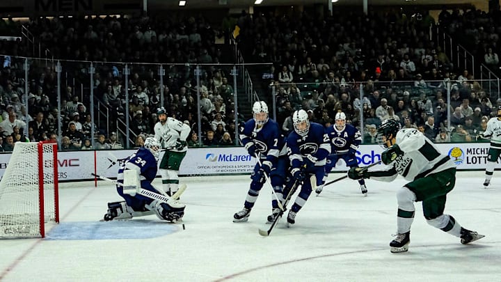 Michigan State's Porter Martone (22) shoots the puck past defenders and Penn State goaltender Josh Fleming (34) late in the first period at Munn Ice Arena Saturday, Nov. 8, 2025.