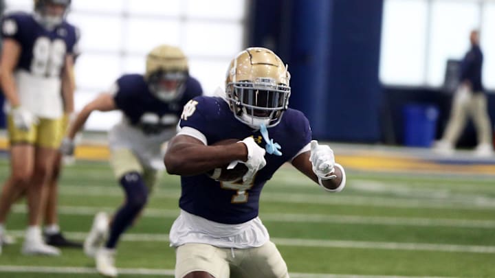 Notre Dame running back Jeremiyah Love runs with the ball after making a catch during a drill in practice