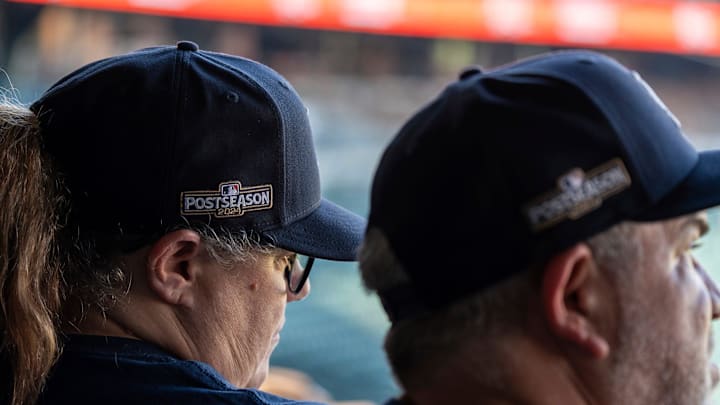 Two people wearing postseason hats watch as the Detroit Tigers take on the Houston Astros during a watch party at Comerica Park in Detroit on Tuesday, Oct. 1, 2024.