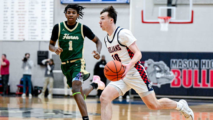 East Lansing's Cameron Essell, right, moves the ball as Ann Arbor Huron's Kaleb Brown closes in during the first quarter on Tuesday, March 11, 2025, at Mason High School.