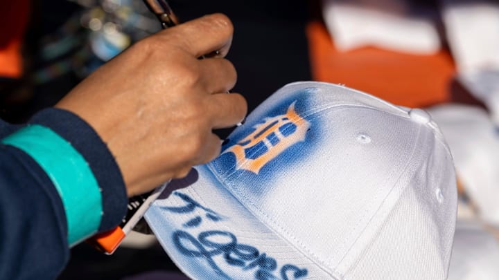 An Airbrushed Stuff employee airbrushes a hat for a fan outside Comerica Park before the Detroit Tigers vs. Cleveland Guardians playoff game in Detroit on Thursday, Oct. 10, 2024.