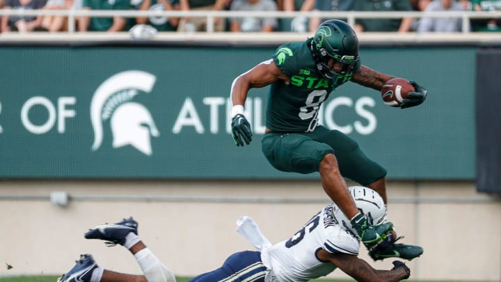 Michigan State running back Jalen Berger runs against Akron defensive back Nate Thompson during the