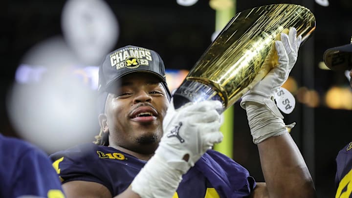 Michigan defensive lineman Kris Jenkins picks up the trophy to celebrate 34-13 win over Washington