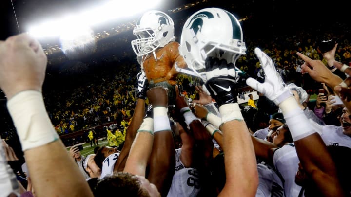 Michigan State players celebrate by raising the Paul Bunyan trophy, which has a Spartan helmet on, Michigan State players celebrate by raising the Paul Bunyan trophy, which has a Spartan helmet on,