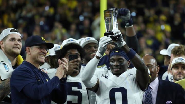 Michigan coach Jim Harbaugh celebrates defensive back Mike Sainristil (0), who was named MVP, after U-M's 26-0 win over Iowa in the Big Ten championship game on Saturday, Dec. 2, 2023, in Indianapolis. Michigan coach Jim Harbaugh celebrates defensive back Mike Sainristil (0), who was named MVP, after U-M's 26-0 win over Iowa in the Big Ten championship game on Saturday, Dec. 2, 2023, in Indianapolis.