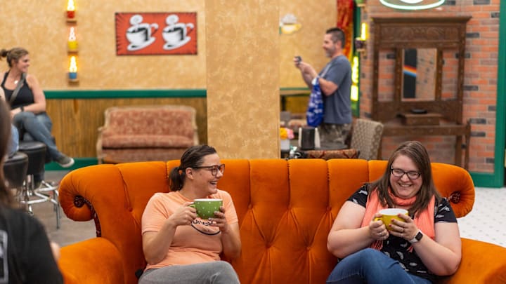 Kristin Lacopelli, right, of Wyandotte and Kasey Brown of Wyandotte sit in the scene for Central Perk while visiting \"The Friends Experience\" on Thursday, June 29, 2023, at Great Lakes Crossing in Auburn Hills. The experience features rooms and props from the TV show Friends.