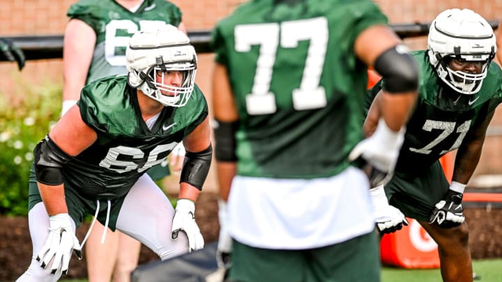 Michigan State's Gavin Broscious, left, and Kristian Phillips run an offensive line drill during the first day of football camp on Tuesday, July 30, 2024, in East Lansing.
