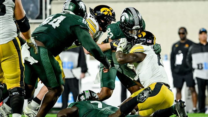 Michigan State's Darius Snow, left, and Jordan Turner, below, tackles Iowa's Kaleb Johnson during the fourth quarter on Saturday, Oct. 19, 2024, at Spartan Stadium in East Lansing.