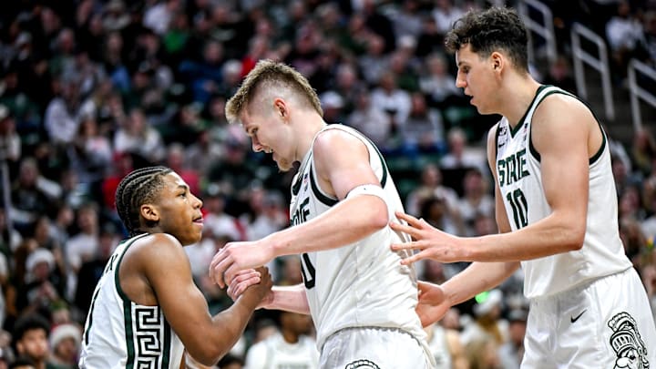 Michigan State's Jaxon Kohler, center, helps Jeremy Fears Jr., left, up off the floor after Fears' scored and drew a Nebraska foul during the second half on Saturday, Dec. 7, 2024, at the Breslin Center in East Lansing. At right is MSU's Szymon Zapala.