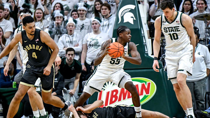 Michigan State's Coen Carr, center, pulls down a rebound over Purdue's Fletcher Loyer, bottom, during the second half on Tuesday, Feb. 18, 2025, at the Breslin Center in East Lansing.