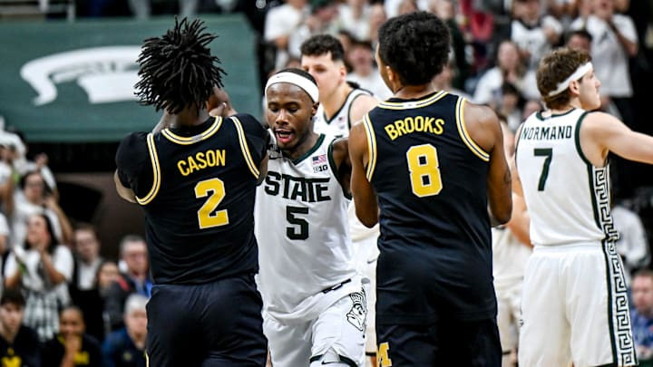 Michigan State's Tre Holloman, center, pushes Michigan's L.J. Cason, left, and Phat Phat Brooks, right, back off the Spartans logo as senior teammates prepare to kiss the floor during the second half on Sunday, March 9, 2025, at the Breslin Center in East Lansing. Michigan State's Tre Holloman, center, pushes Michigan's L.J. Cason, left, and Phat Phat Brooks, right, back off the Spartans logo as senior teammates prepare to kiss the floor during the second half on Sunday, March 9, 2025, at the Breslin Center in East Lansing.
