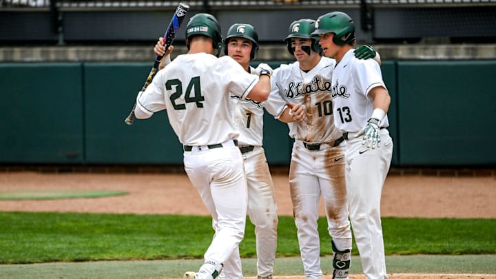 Michigan State's Sam Busch, left, crosses home plate after a home run against Ohio State during the fifth inning on Friday, April 18, 2025, at McLane Stadium in East Lansing. From left, MSU's Ryan McKay, Nick Williams and Parker Picot greet Bush at the plate.
