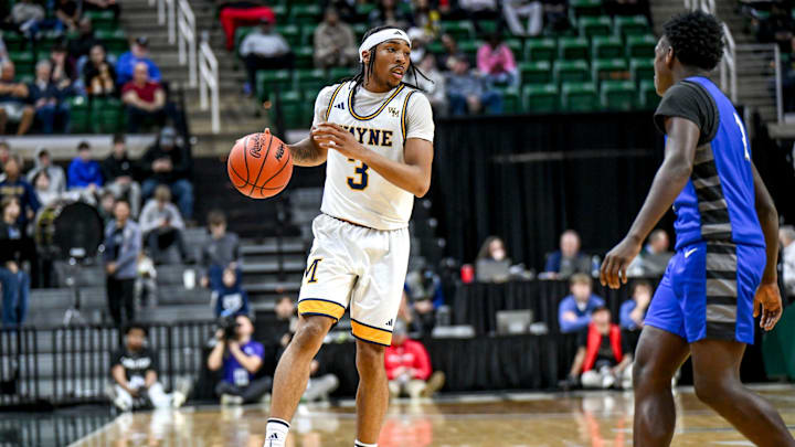Wayne Memorial's Carlos Medlock Jr. moves the ball against Flint Carman-Ainsworth during the second quarter in the Division 1 state semifinal on Friday, March 14, 2025, at the Breslin Center in East Lansing.