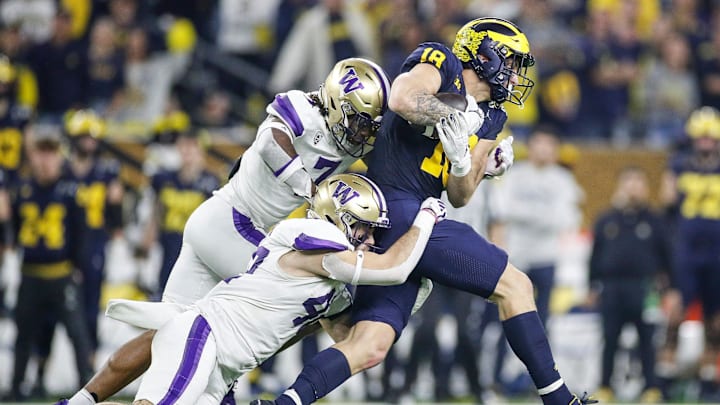 Michigan tight end Colston Loveland (18) makes a catch against Washington linebacker Carson Bruener (42) and cornerback Dominique Hampton (7) during the first half of the national championship game at NRG Stadium in Houston on Monday, Jan. 8, 2024.