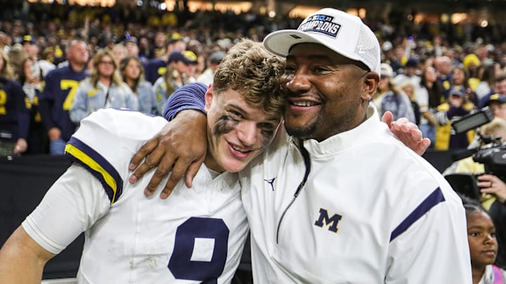 Michigan quarterback J.J. McCarthy and wide receivers coach Ron Bellamy celebrate U-M's 26-0 win over Iowa in the Big Ten championship game in Indianapolis on Saturday, Dec. 2, 2023.